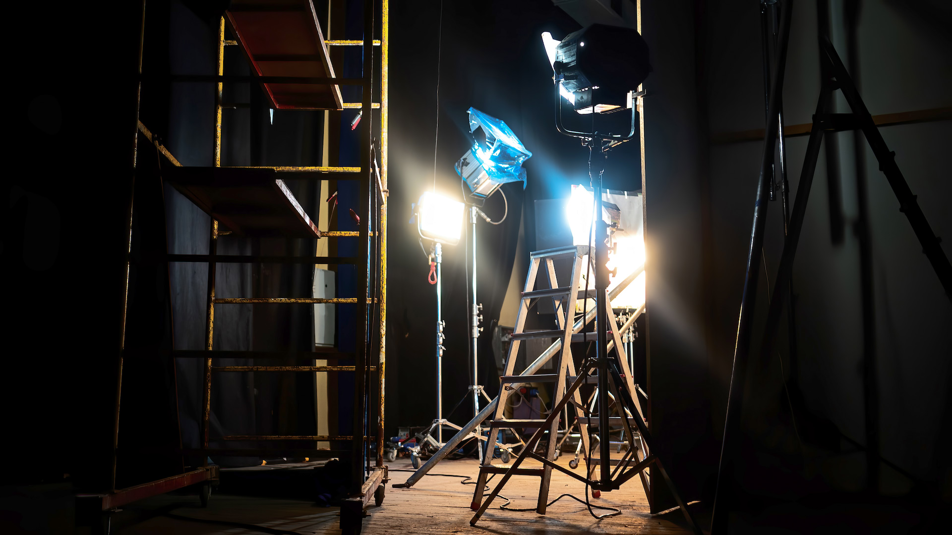 Film lights, stands and scaffolding on a dark stage