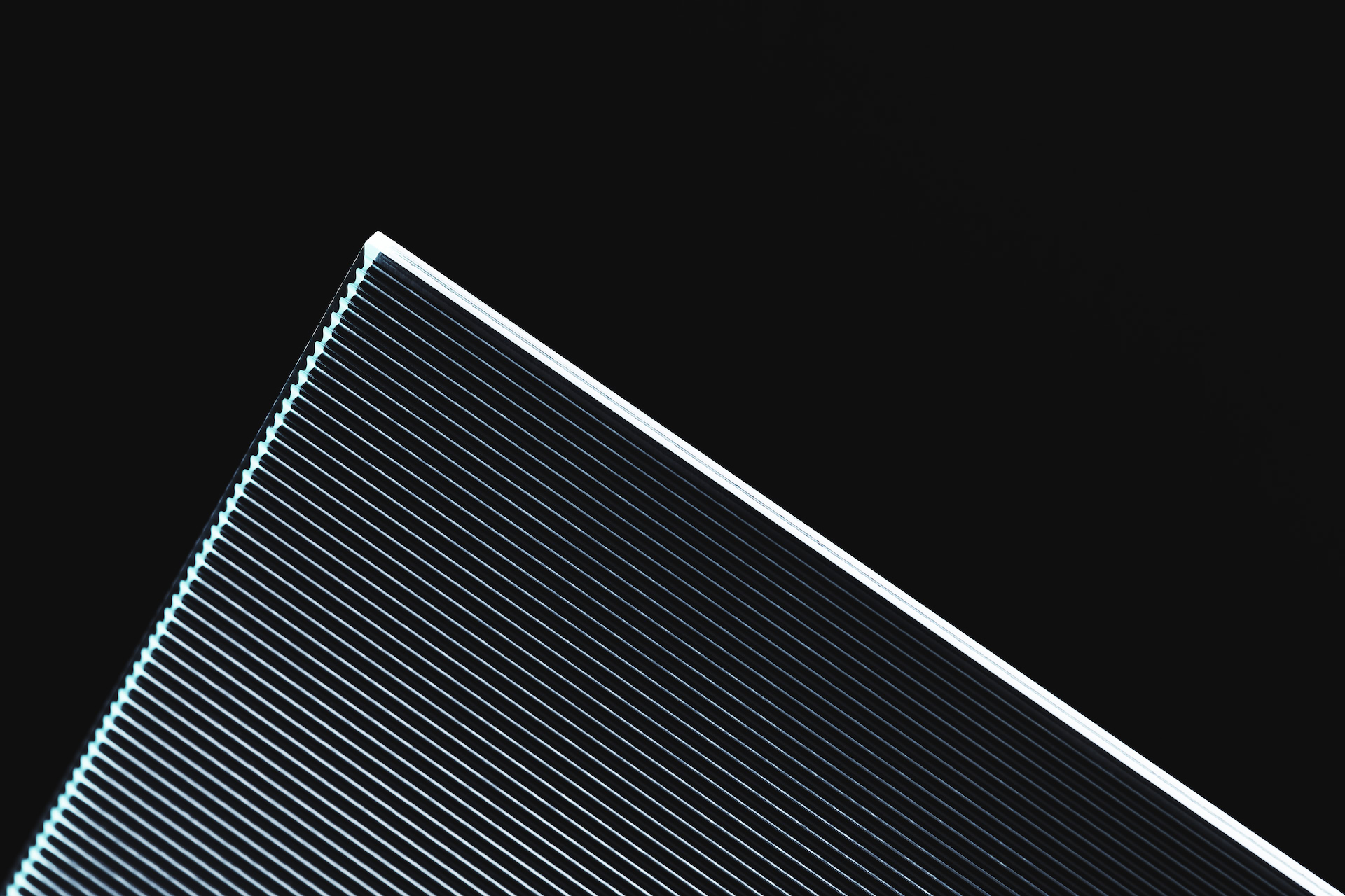 A ribbed glass panel edged with a line of white light against black